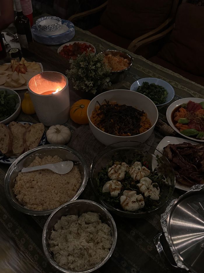 Overhead view of a fall dinner spread with pasta, burrata salad, and rice