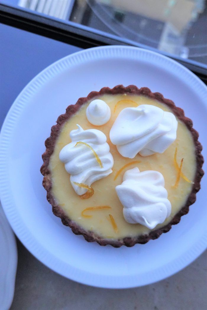 Lemon tart with meringue kisses and candied orange peel, overhead view